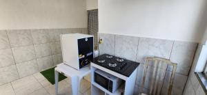 新伊瓜苏Kitinet aconchegante em Nova Iguaçu的一间带炉灶和微波炉的小厨房