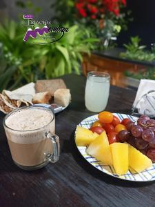 门多萨门多萨艾斯塔星旅舍的一张桌子,上面放有水果盘和一杯咖啡