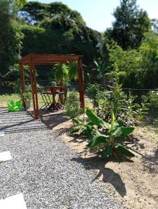 圣塞巴斯蒂安Recanto do Sossego的一个带木桌和一些植物的花园