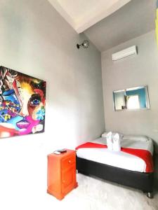 卡塔赫纳La Viduka Hostel的一间卧室设有两张床,墙上挂着一幅画