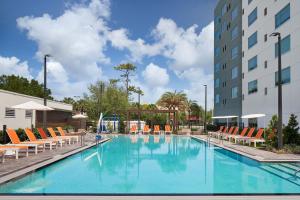 奥兰多Element Orlando International Drive的一座带椅子的大型游泳池和一座建筑