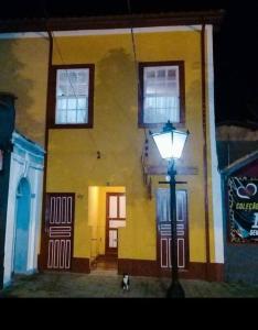 圣路易斯-杜帕赖廷加Casa Centenária localizada no calçadão de SLP的黄色建筑前的街道灯