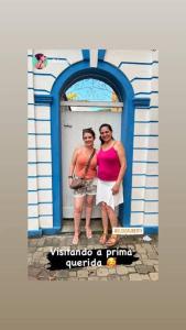 圣路易斯-杜帕赖廷加Casa Centenária localizada no calçadão de SLP的两名妇女站在一座建筑物前面
