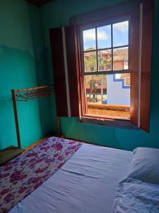 圣路易斯-杜帕赖廷加Casa Centenária localizada no calçadão de SLP的一间卧室设有一张床和一个窗口