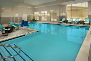 泰勒泰勒公寓式酒店的一个带蓝色桌椅的大型游泳池