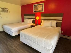 Westfield高速公路假日汽车旅馆的红色墙壁的酒店客房内的两张床