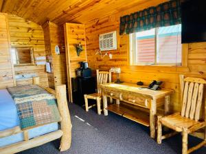 沃尔Badlands Frontier Cabins的小屋内设有一间带书桌和桌子的卧室