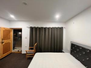 列城Chubar home stay的一间卧室配有床和灰色窗帘