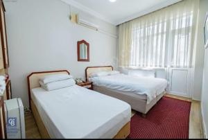 埃德雷米特AKÇAY LEMAN OTEL的一间卧室设有两张床和窗户。
