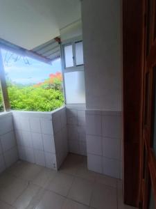 阿约拉港加拉帕戈斯佛得角阿祖尔酒店的浴室设有白色瓷砖墙壁和窗户。