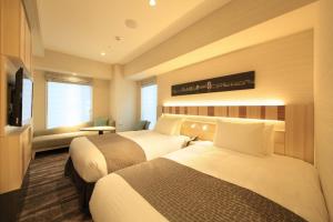 东京银座灿路都大饭店的酒店客房设有两张床和电视。