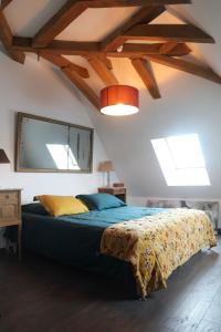 CéronLes Jardins des Soussilanges的一间卧室配有一张带蓝色棉被的床
