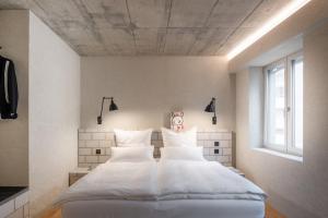 卢加诺B5 Boutique Hotel - NEW OPENING的一间卧室配有带白色床单和枕头的床。