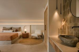阿尔戈斯托利翁Veranda Suite的一间卧室配有一张床,浴室设有水槽