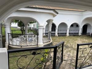 Ile-IfeRoyal Diadem Villa的带阳台的建筑,设有门柱