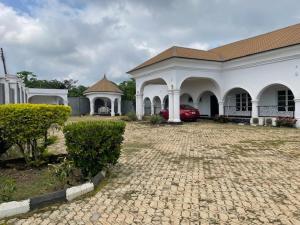 Ile-IfeRoyal Diadem Villa的车道上白色的建筑,有红色的汽车