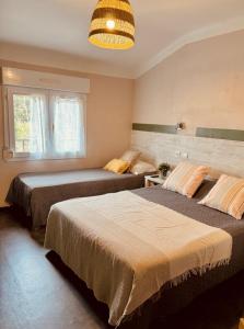 滨海阿热莱斯尼德酒店的一间卧室设有两张床和大窗户