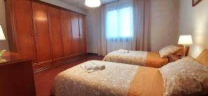 蒙特卡蒂尼泰尔梅[TERME] CASA IN STILE CLASSICO IN TOSCANA CON TERRAZZO的酒店客房设有两张床和窗户。