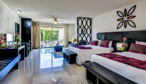 普拉亚卡门科拉松套房酒店的一间带两张床的卧室和一间客厅