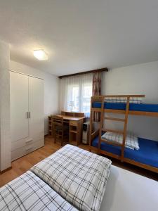 Saas-BalenHoliday House Lärchenheim的一间卧室设有两张双层床和一张桌子