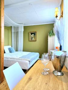 哥本哈根Guesthouse 'Blue House' in vintage villa&garden的一间卧室配有一张床和一张带酒杯的桌子