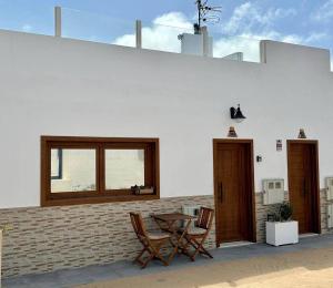 塞博河畔卡莱塔La Graciosita Traditional Home的庭院设有两把椅子、一张桌子和一扇窗户。