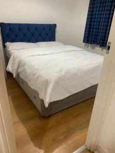 斯劳3 Bedroom Home Near Windsor Castle, Legoland, & Heathrow的卧室里一张带蓝色床头板的床