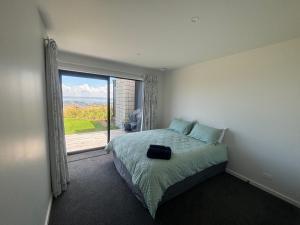 罗托鲁瓦Totara Ridge的一间卧室设有一张床和一个大窗户