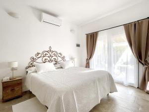 奥尔比亚Sea Love的白色的卧室设有一张大床和一个窗户