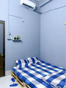 芹苴Nhà Nghỉ Thành Đạt的一间卧室配有一张蓝色和白色条纹的床