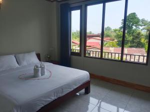 万荣Vang Vieng Champa Hotel的一间卧室设有一张床和一个大窗户