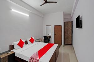 诺伊达OYO Hotel Grand Shiva的一间卧室配有一张带红色枕头的大床