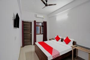 诺伊达OYO Hotel Grand Shiva的一间卧室配有一张带红色枕头的床