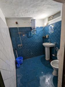阿尔莫拉Resort Blue Lotus的蓝色瓷砖浴室设有卫生间和水槽