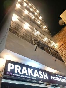 瓦拉纳西HOTEL PRAKASH GUEST HOUSE ! Varanasi ! fully-Air-Conditioned hotel at prime location with Parking availability, near Kashi Vishwanath Temple, and Ganga ghat的建筑物一侧的守护动物药房标志