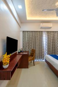 浦那StayBird - Divine Suites, Business Hotel, Kharadi的酒店客房设有电视、床和书桌