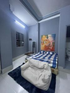 芹苴Nhà Nghỉ Thành Đạt的卧室配有一张床,墙上挂有绘画作品
