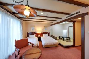 郡上市太阳成员西路嘉诺酒店的一间卧室配有两张床、一把椅子和一张桌子
