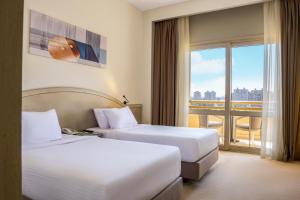 开罗Triumph Plaza Hotel的酒店客房设有两张床和窗户。