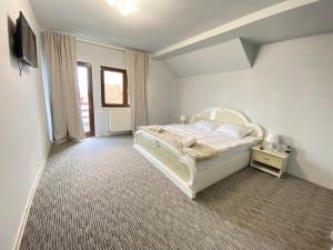 科马尔尼克Casa Polen Comarnic的卧室配有白色的床和电视。