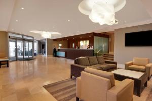 卡尔加里卡尔加里机场假日酒店的大堂配有沙发、椅子和电视