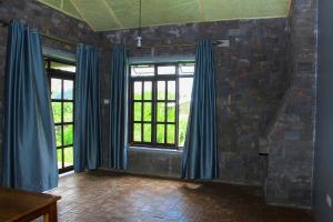 KisoroLake Chahafi Resort的一间空房间,配有蓝色窗帘和窗户
