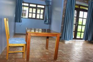 KisoroLake Chahafi Resort的窗户间配有一张木桌和椅子