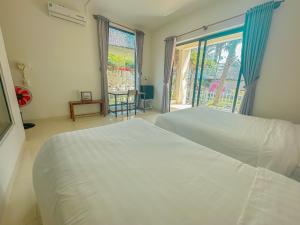 雷特Paradise Resort Doc Let的一间卧室设有两张白色的床和窗户