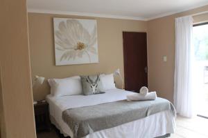 玛洛斯帕克Kruger Bush Retreat的卧室配有一张挂着花卉图案的床。
