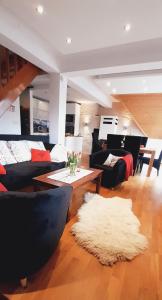 考斯赛力克Apartament Twój Giewont Zakopane的客厅配有黑色沙发和白色地毯。