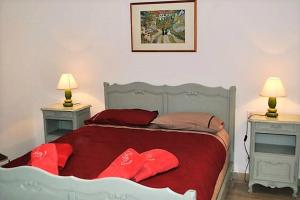 阿尔勒La Bigotière avec clim et jardin的一间卧室配有一张带红色枕头的床