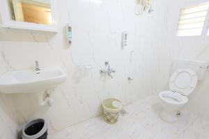 钦奈Izi Transit Stay的白色的浴室设有卫生间和水槽。