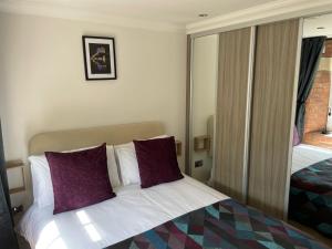 约克Staycation York at Cocoa Suites的配有紫色枕头的床的酒店客房