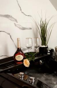 沙勒罗瓦Logement romantique et cosy的桌子上放有一瓶葡萄酒和两杯酒